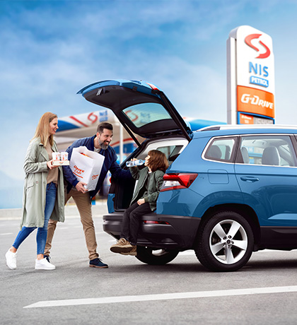 family packing products in car at nis petrol station